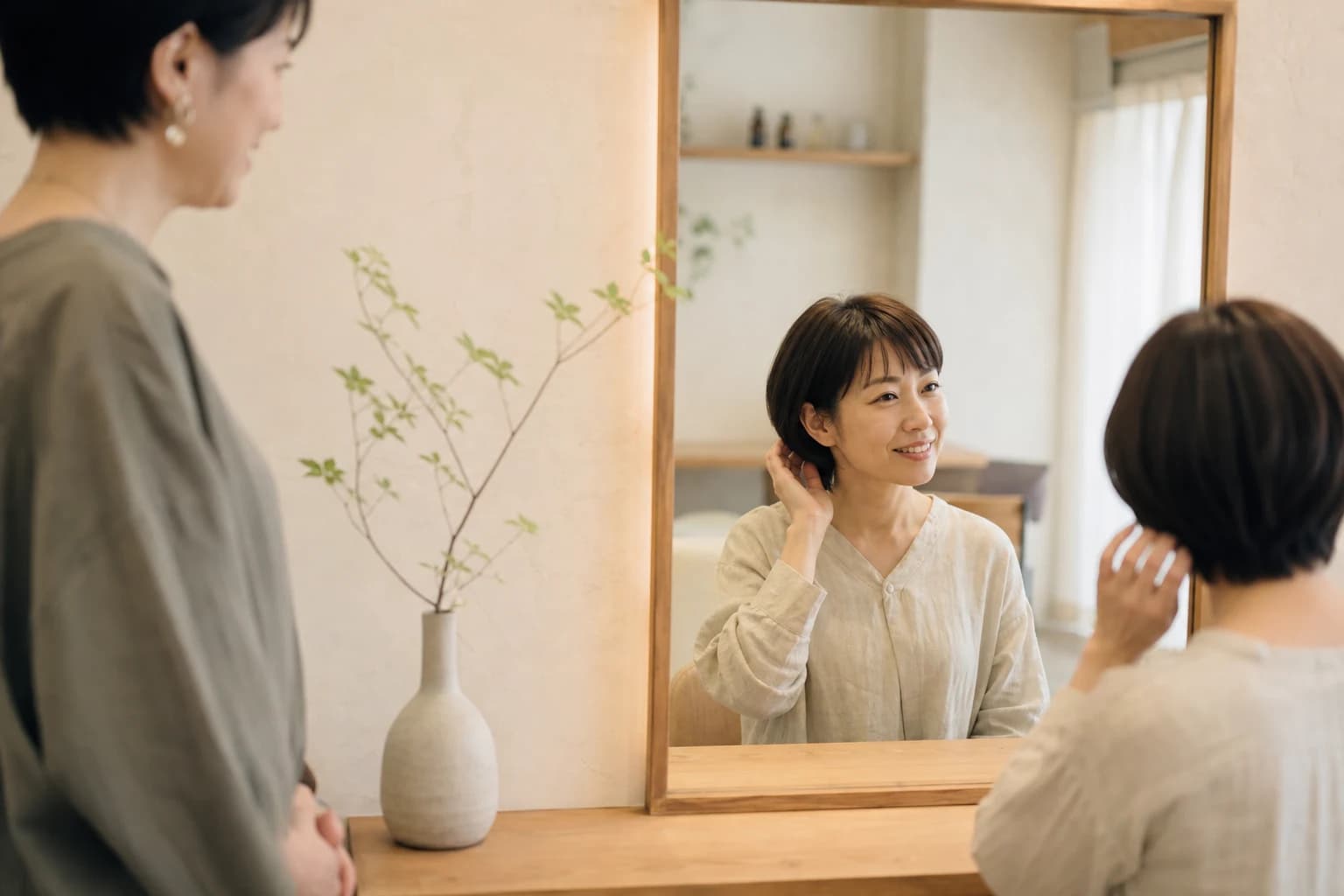 施術後の仕上がりを笑顔で確認するお客様